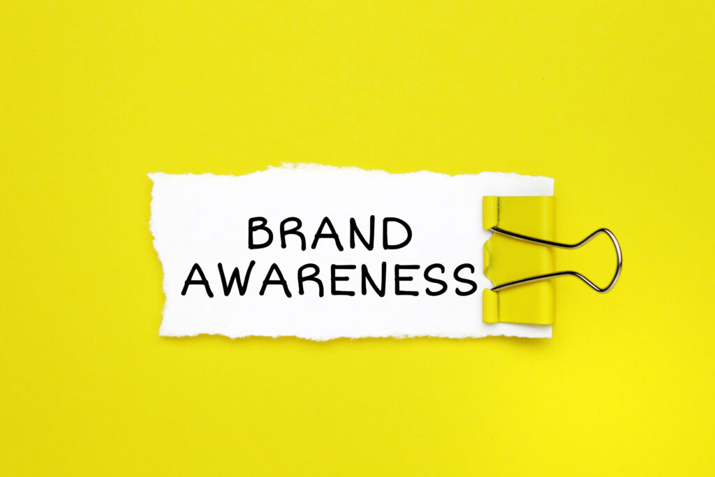 "Brand Awareness" written on a paper with a yellow clip.