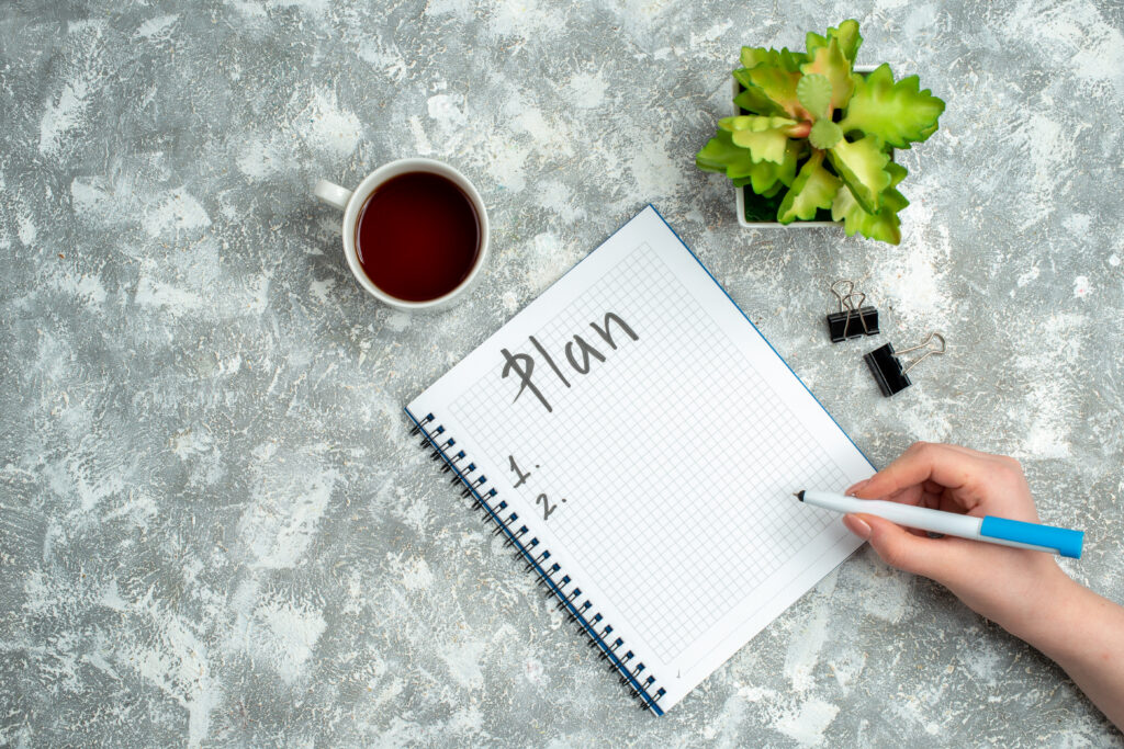 A hand writing personal development plan on a notebook.